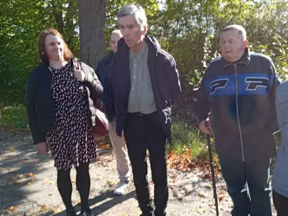 Mieszkańcy z opiekunką na ścieżce w skansenie