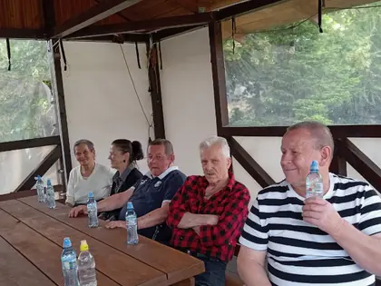 Mieszkańcy siedzą przy stole w altanie z wodą