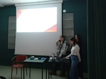 Studentki prowadzą prelekcję przy ekranie z prezentacją