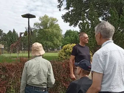 Mieszkańcy z opiekunami w parku przy zoo
