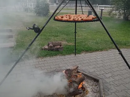 Kociołek na trójnogu nad dymiącym ogniskiem