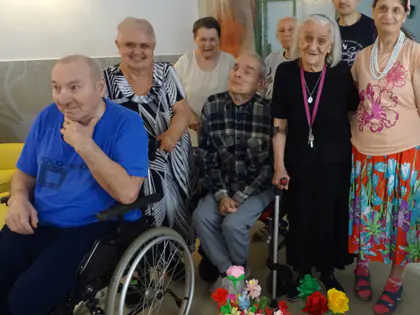 Mieszkańcy pozują z kolorowymi kwiatami z bibuły