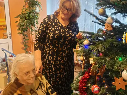 Pracownica i mieszkanka ubierają choinkę