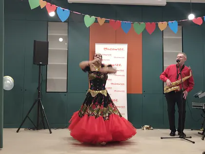 Tancerka w czerwonej sukni i saksofonista na scenie