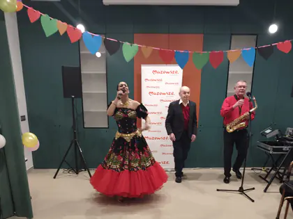 Śpiewaczka w czerwono-czarnej sukni i saksofonista na scenie