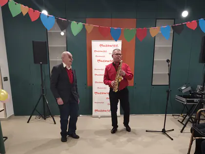 Dwaj muzycy na scenie, jeden z saksofonem