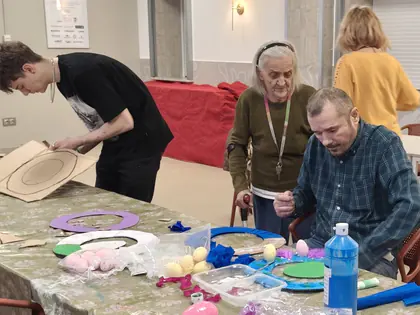 Chłopak, mieszkanka i mieszkaniec robią ozdoby przy stole