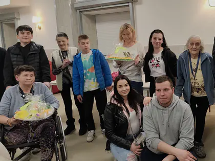 Mieszkańcy i młodzież pozują z nagrodami w świetlicy