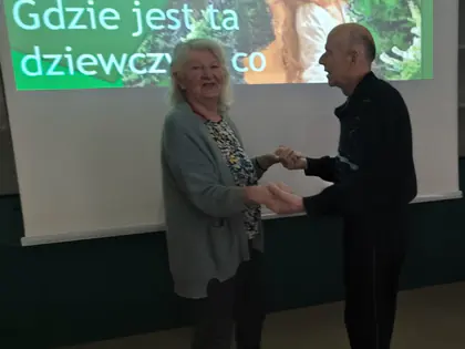 Para mieszkańców tańczy przed ekranem z tekstem piosenki Gdzie jest ta ulica