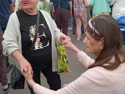 Mieszkanka trzyma za rękę mieszkankę na wózku pod namiotem