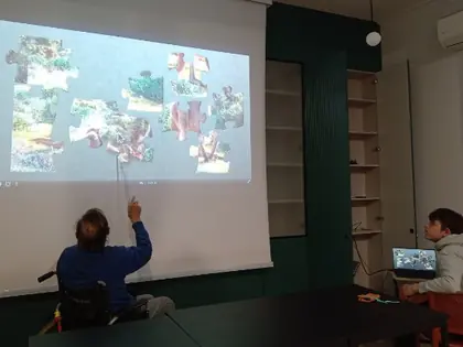 Mężczyzna na wózku wpatrzony w duży kolorowy ekran