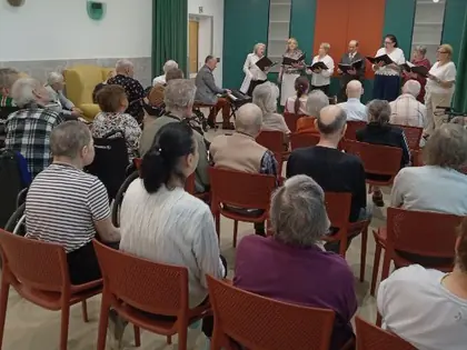 Mieszkańcy słuchają chóru w świetlicy