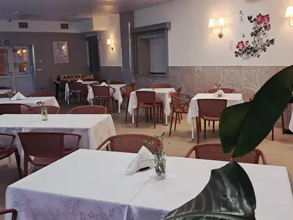 Jadalnia z nakrytymi stołami i kwiatami
